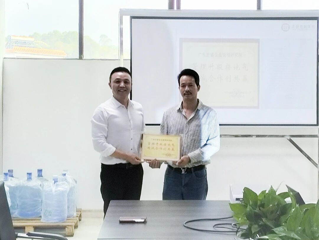 铭凯总经理张干赢先生（右）向正睿咨询集团颁发荣誉牌匾